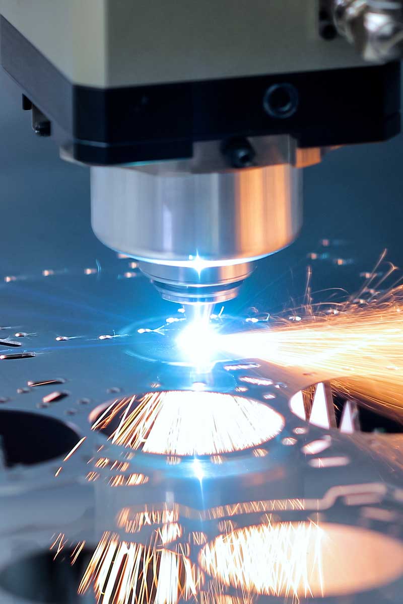 Fibre laser cutting head laser cutting stainless steel with sparks flying – precision laser cutting at Laserteile Online